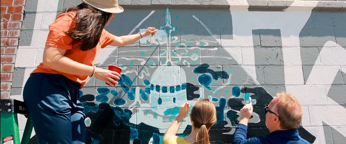 Mount Mercy students painting a mural of the Warde Hall cupola